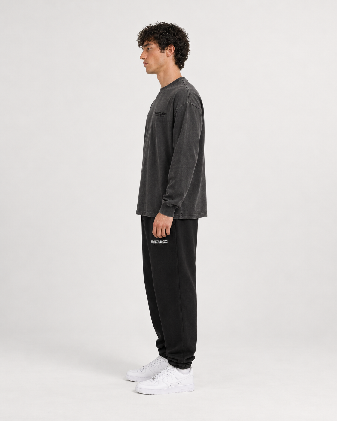 AI-generated styling illustration: Dreamers Distressed Luxury Long Sleeve Tee with AAO black sweatpants, three-quarter view.