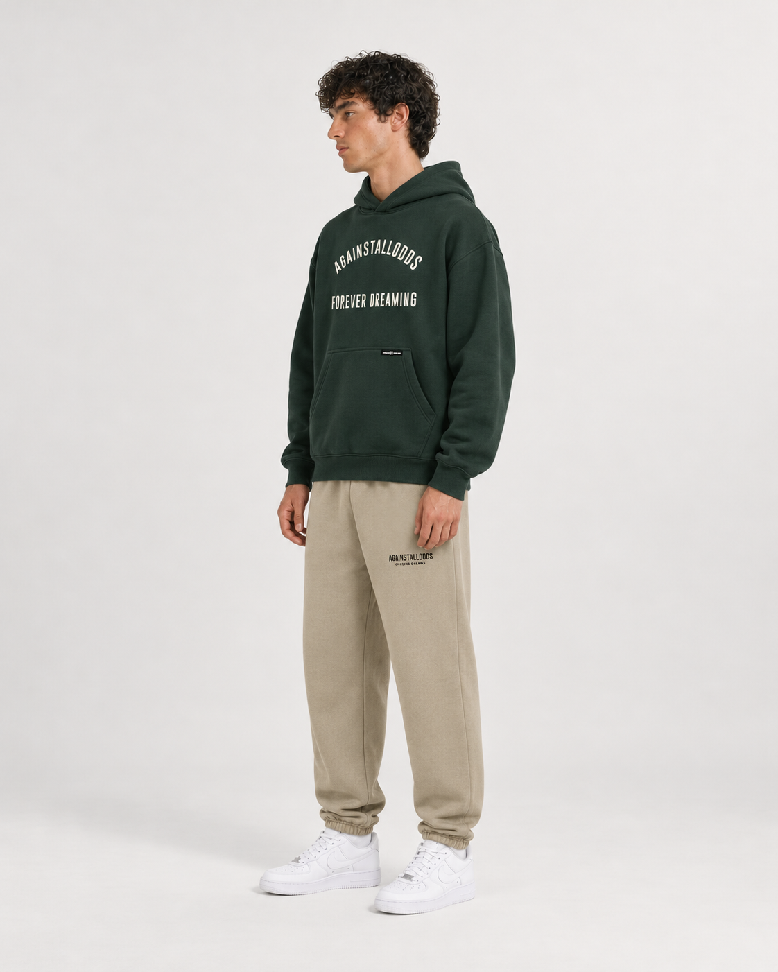 AI-generated styling illustration: College Green Luxury Hoodie with AAO Sandune sweatpants, side view.