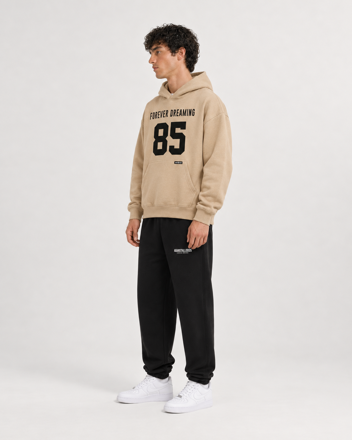 AI-generated styling illustration: 85 Coffee Luxury Hoodie with AAO black sweatpants, side view.