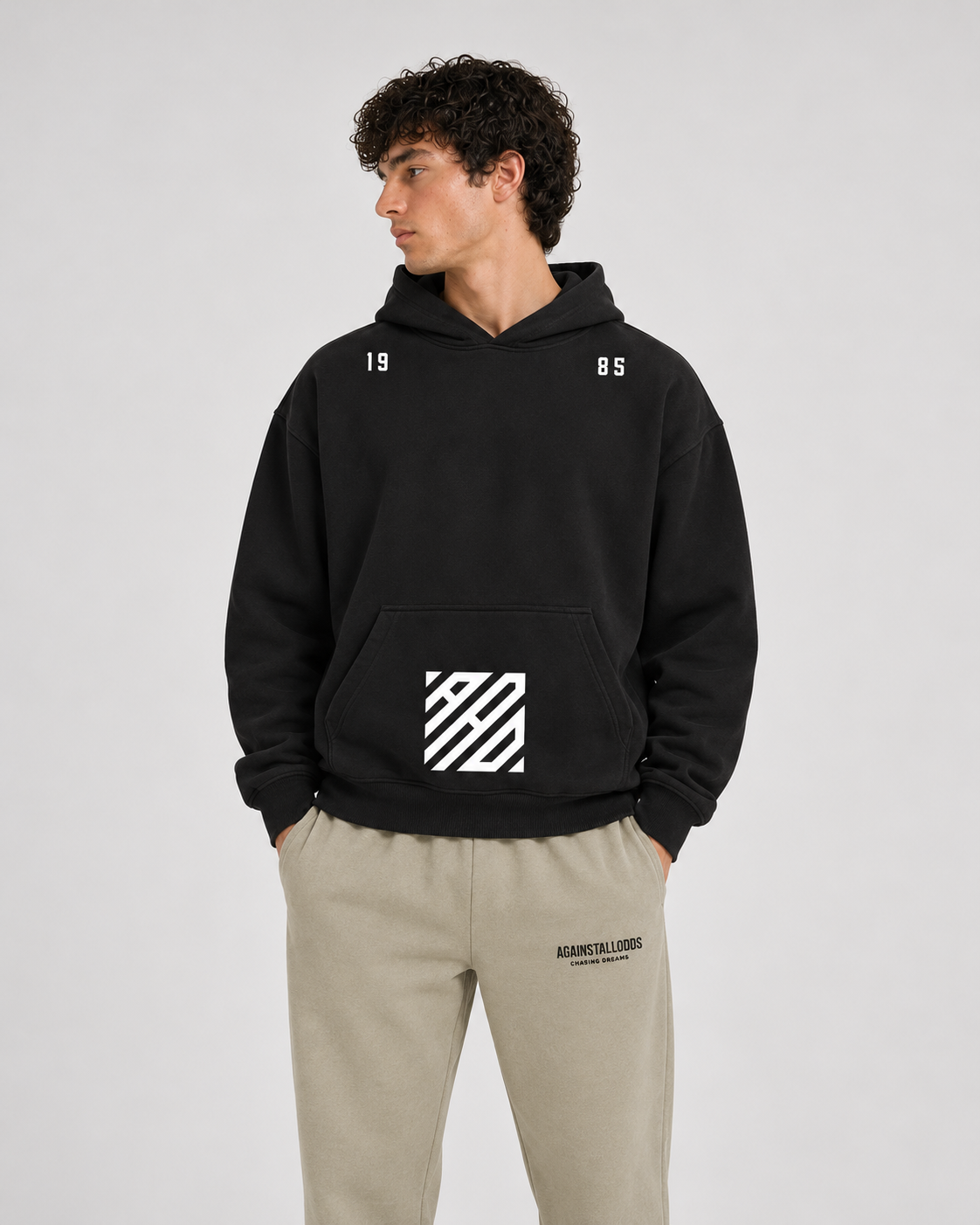 AI-generated styling illustration: AAO Tribute black hoodie with AAO Sandune sweatpants, closer view.