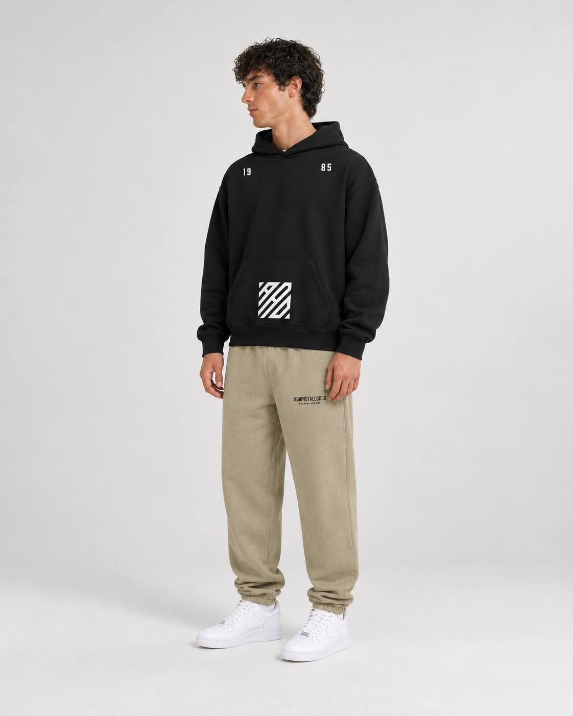 AI-generated styling illustration: AAO Tribute black hoodie with AAO Sandune sweatpants, front view.