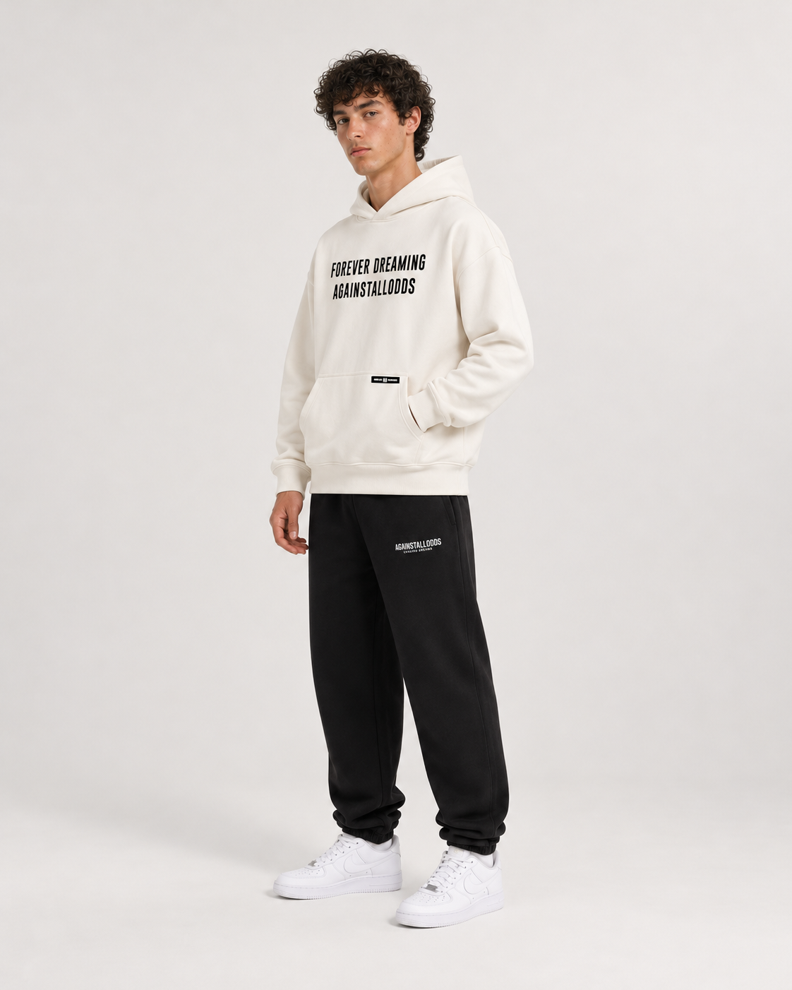 AI-generated styling illustration: AAO Forever Dreaming Ivory Luxury Hoodie with AAO black sweatpants, side view.
