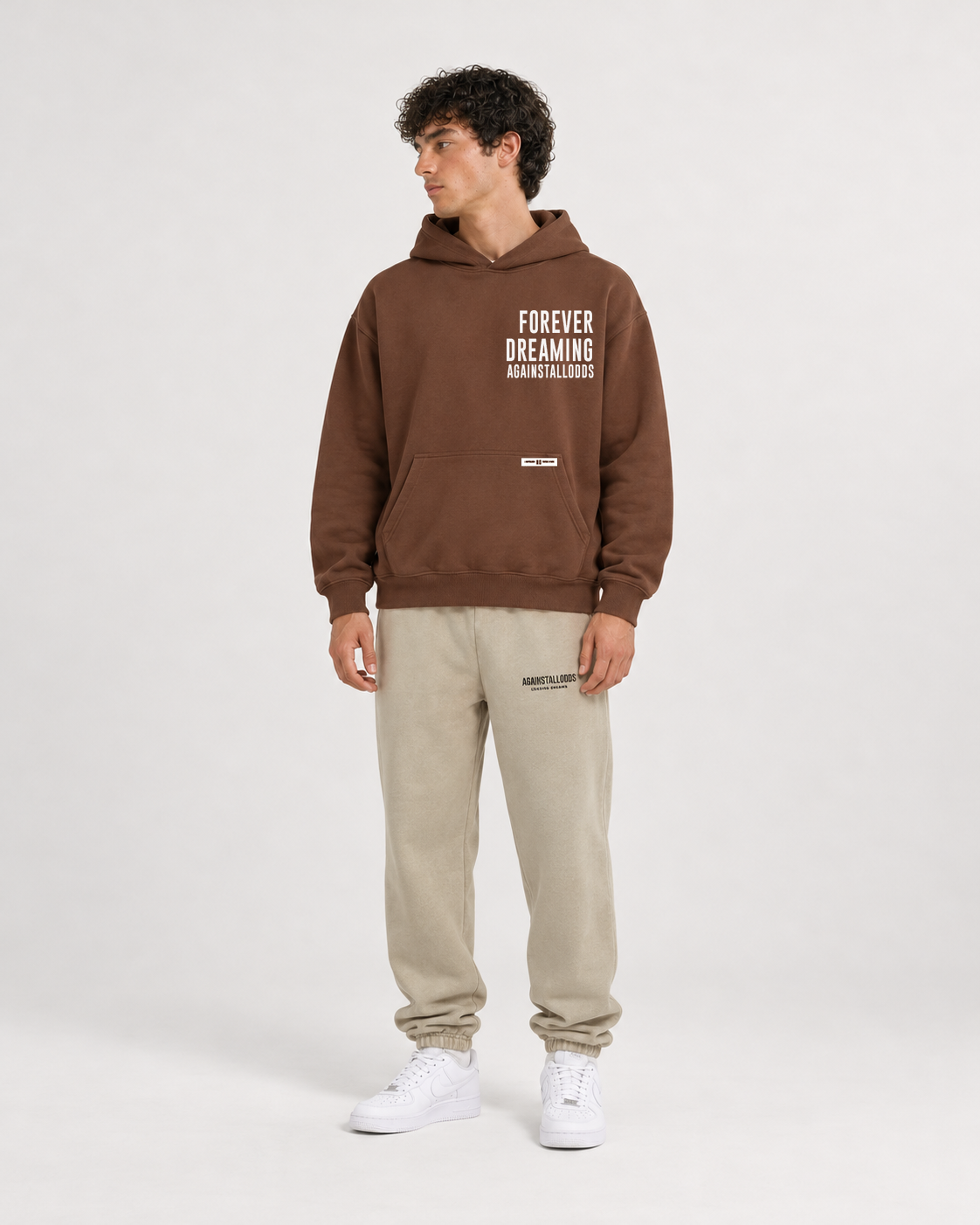 AI-generated styling illustration: AAO Forever Dreaming Brown Luxury Hoodie with AAO Sandune sweatpants, front view.