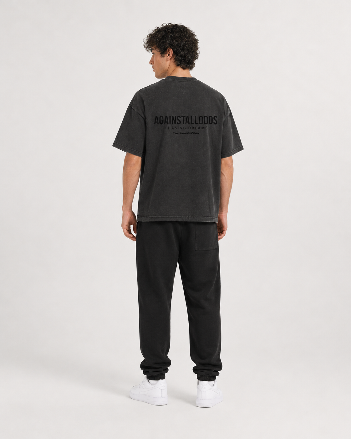 AI-generated styling illustration: Dreamers distressed luxury boxy tee with AAO black sweatpants, back view.