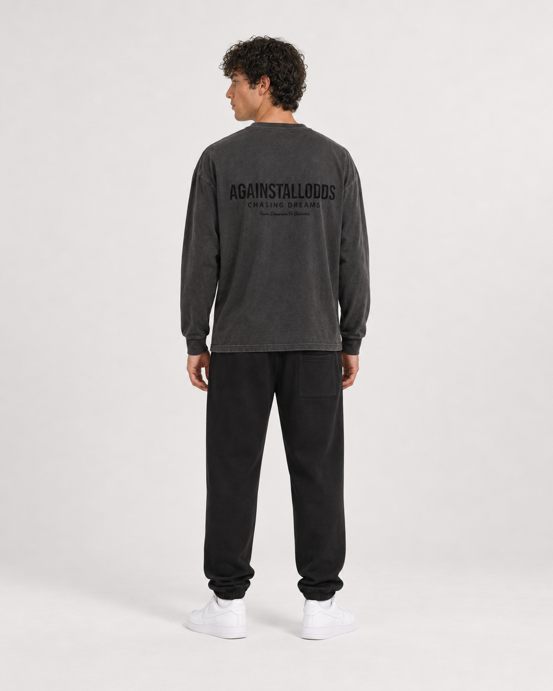 AI-generated styling illustration: Dreamers Distressed Luxury Long Sleeve Tee with AAO black sweatpants, back view.