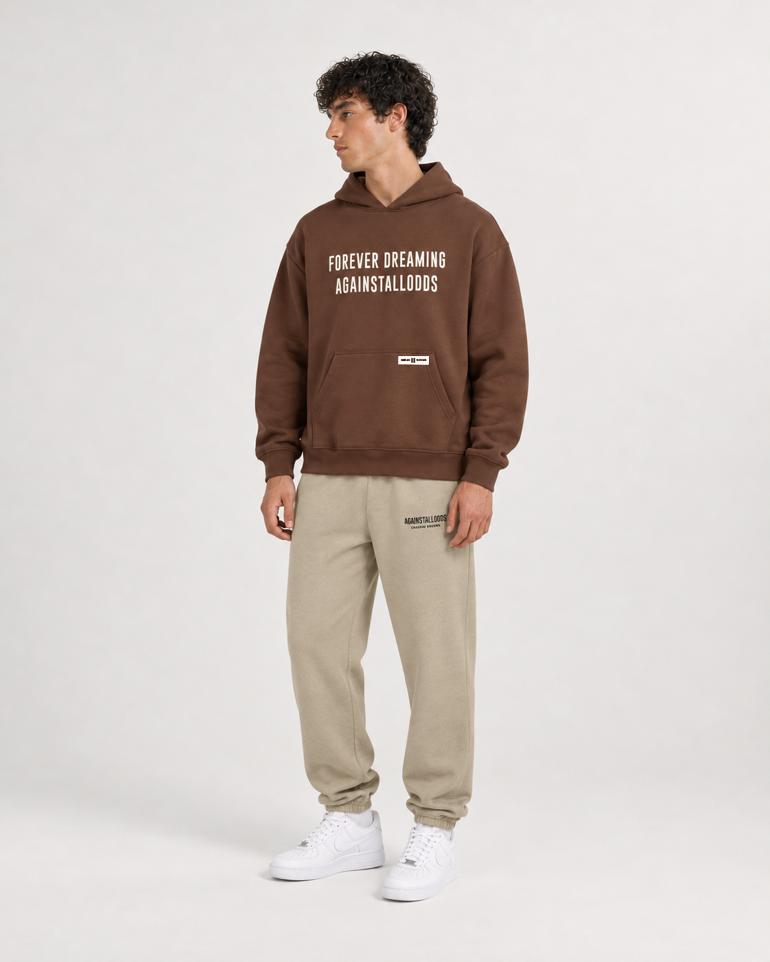 AI-generated styling illustration: AAO Forever Dreaming Brown Luxury Hoodie with AAO Sandune sweatpants, front view.