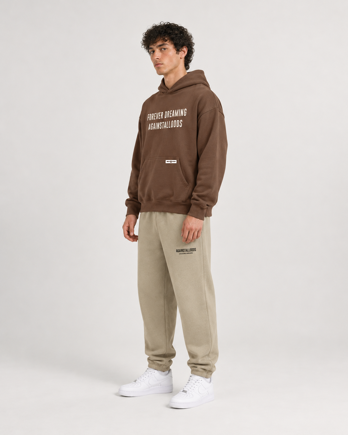 AI-generated styling illustration: AAO Forever Dreaming Brown Luxury Hoodie with AAO Sandune sweatpants, side view.