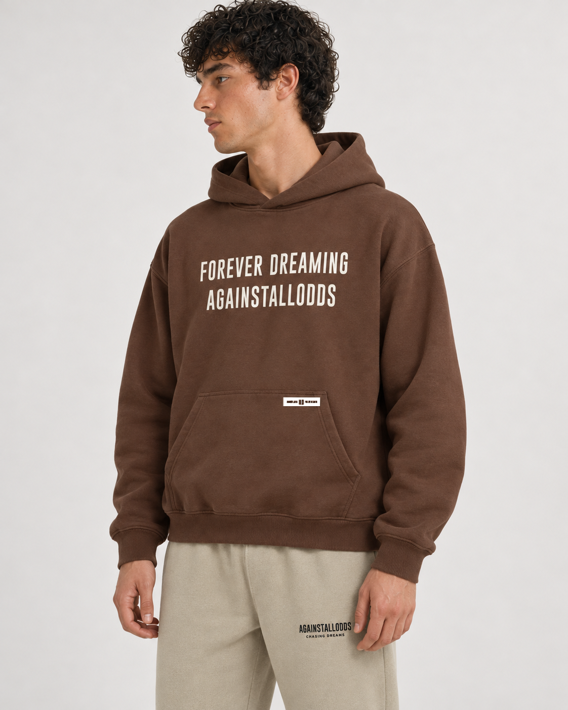 AI-generated styling illustration: AAO Forever Dreaming Brown Luxury Hoodie with AAO Sandune sweatpants, closer view.