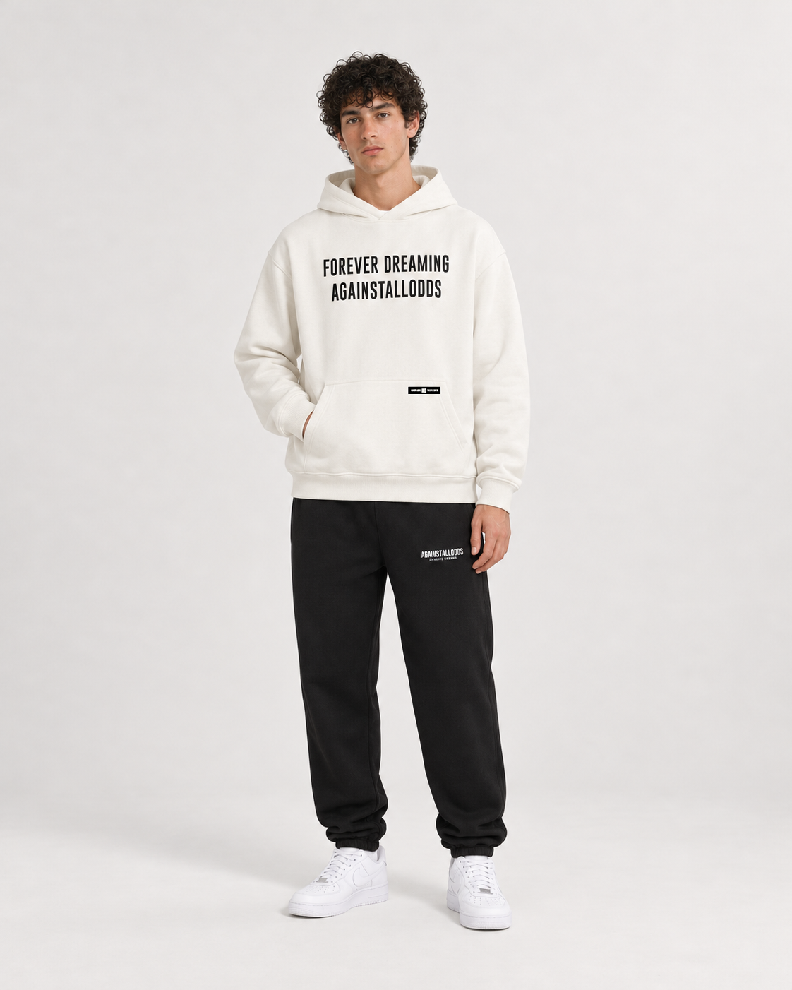 AI-generated styling illustration: AAO Forever Dreaming Ivory Luxury Hoodie with AAO black sweatpants, front view.