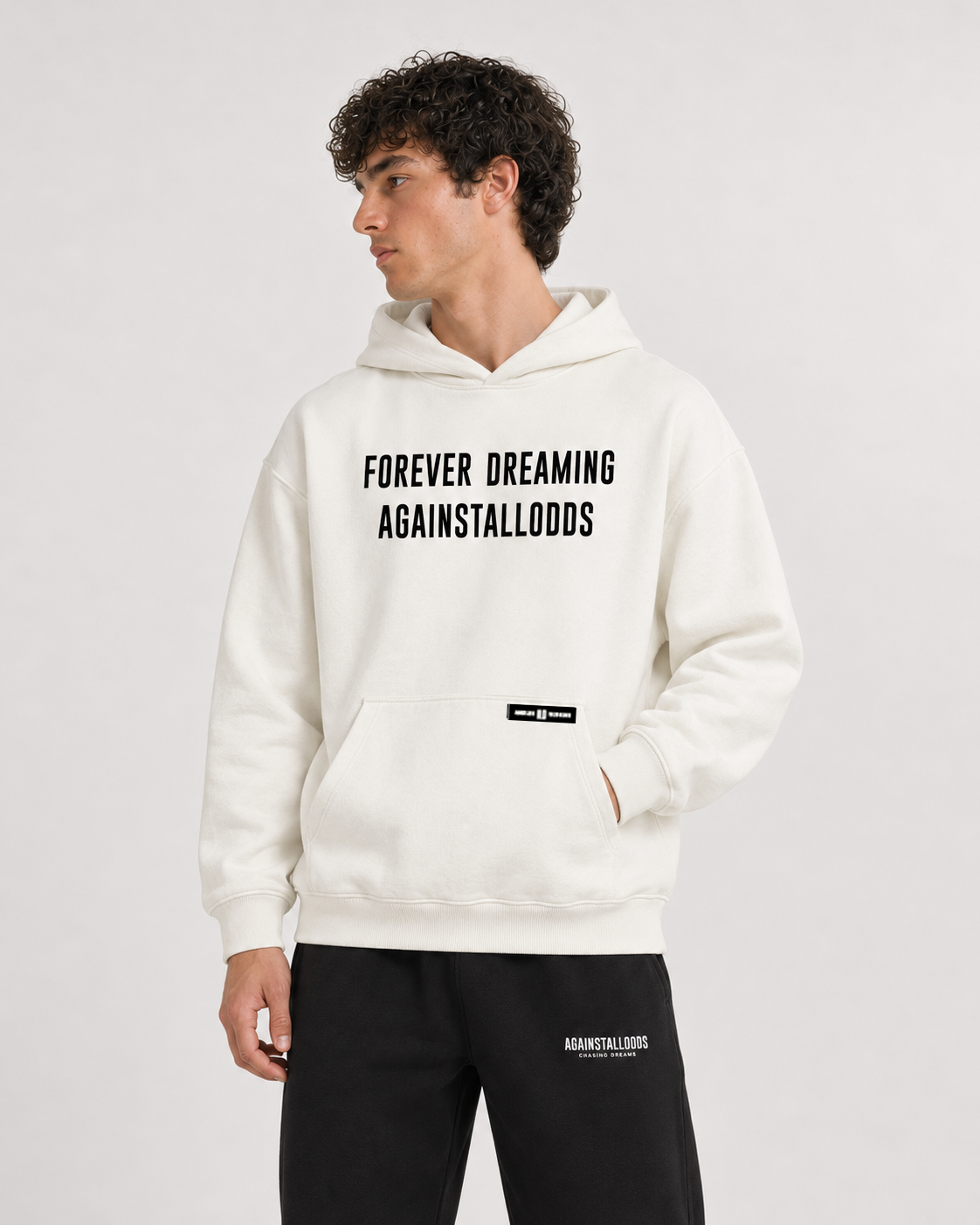 AI-generated styling illustration: AAO Forever Dreaming Ivory Luxury Hoodie with AAO black sweatpants, closer view.