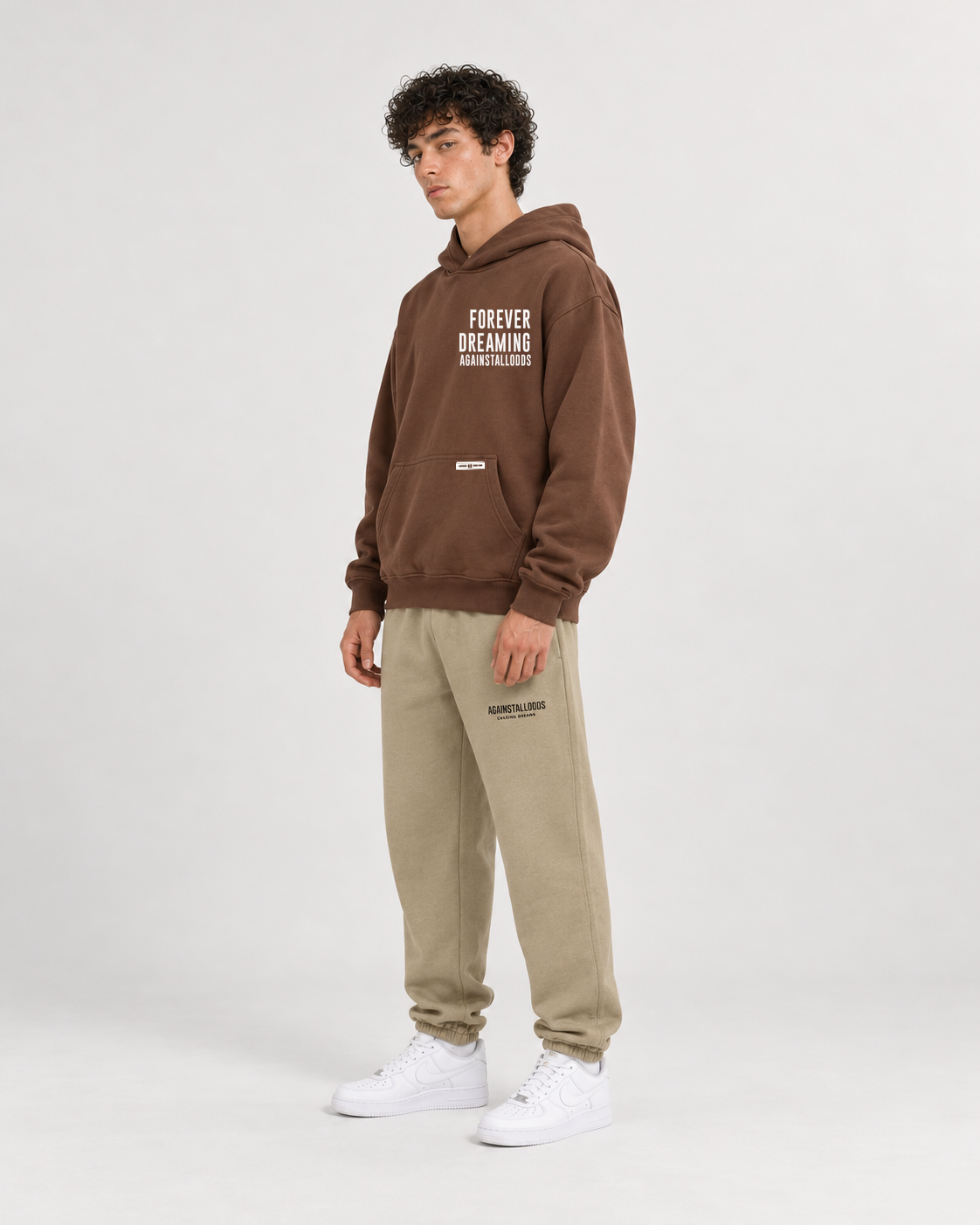 AI-generated styling illustration: AAO Forever Dreaming Brown Luxury Hoodie with AAO Sandune sweatpants, side view.