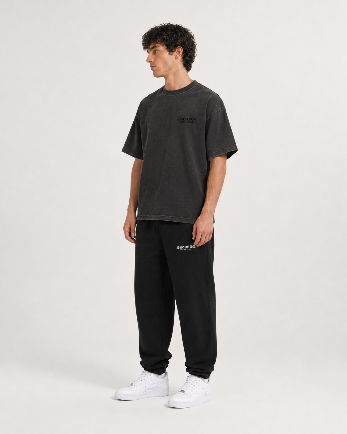 AI-generated styling illustration: Dreamers distressed luxury boxy tee with AAO black sweatpants, front view.